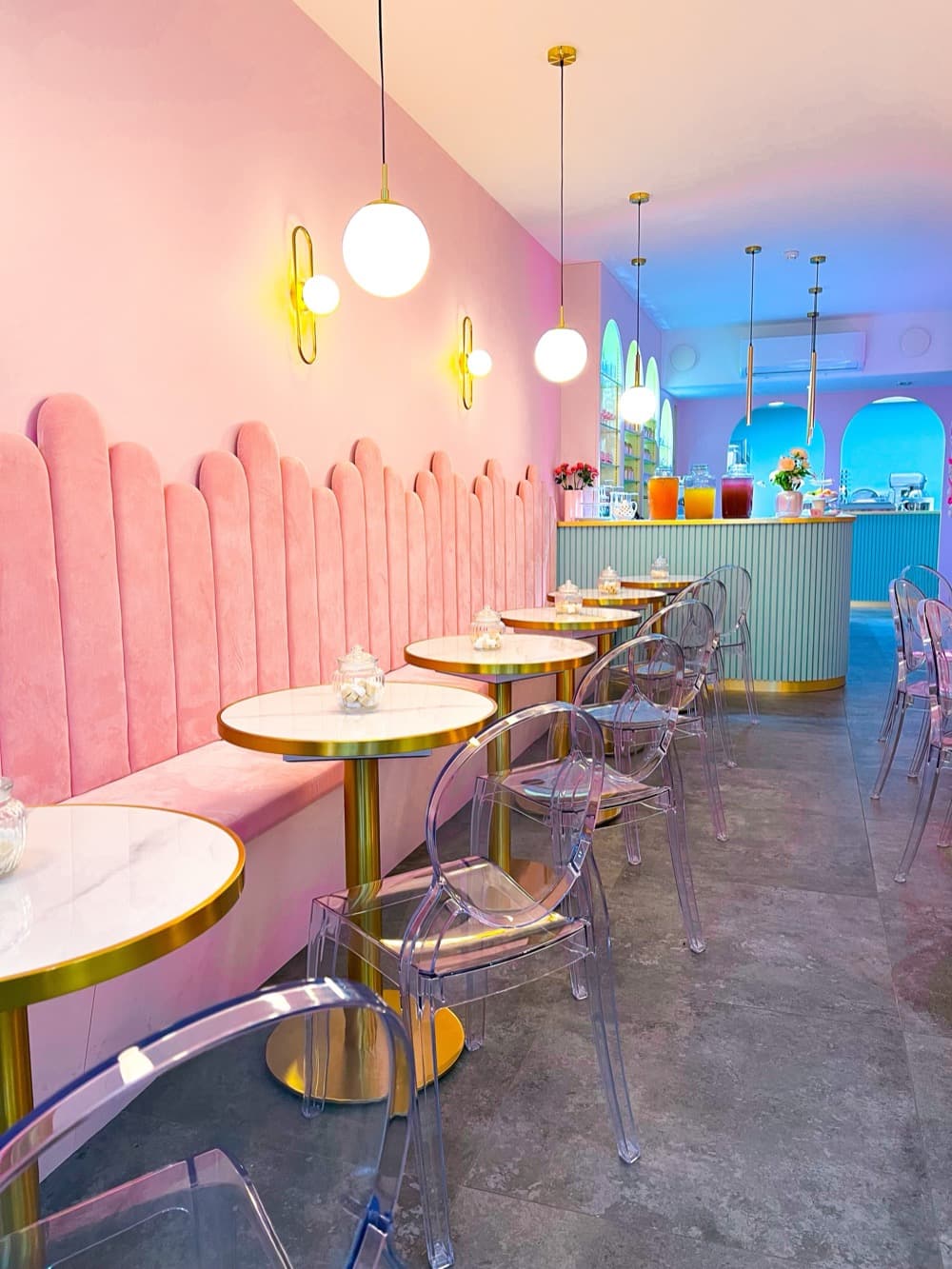 Banquettes roses et luminaires dorés